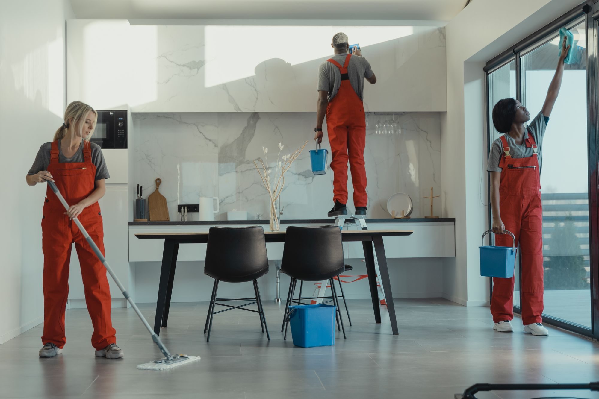 Uniformed cleaning crew mopping and wiping down a modern interior